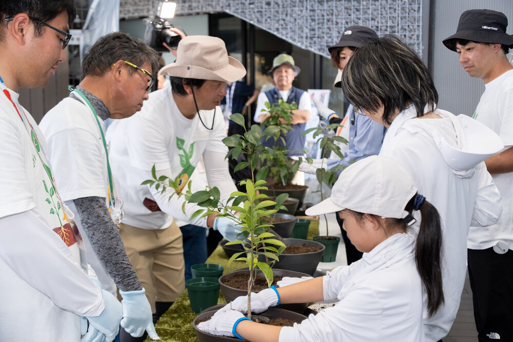 TEAM EXPOパビリオンでスタッフと苗木の植栽を体験する参加者